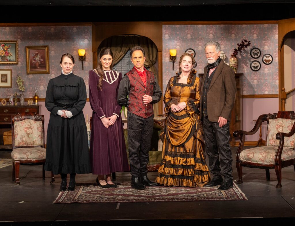 Ensemble in ornate Victorian costumes on stage